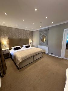 a large bedroom with a large bed and a window at Langtry Manor Hotel in Bournemouth