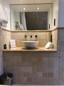 a bathroom with a sink and a mirror at Langtry Manor Hotel in Bournemouth