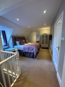 a bedroom with a bed in a room with a staircase at Langtry Manor Hotel in Bournemouth