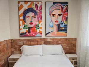 two paintings above a bed in a bedroom at Edificio Aptos Turisticos - Burgos Centro HC7 in Burgos +33 photos