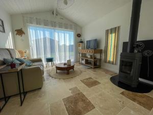 a living room with a wood stove and a couch at TI KAZ - Terrasse extérieure - 5mn Plage in Pleubian