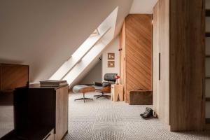 an attic room with a staircase and a chair at Stefanova Zakopane Aparthotel & Spa in Zakopane