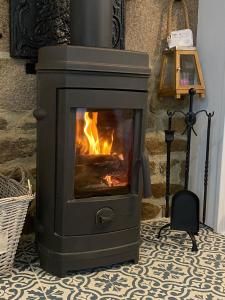 a stove with a fire in a room at The Stable in Sourdeval