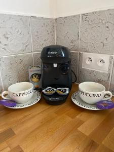a coffee maker and two cups on a table at The Stable in Sourdeval