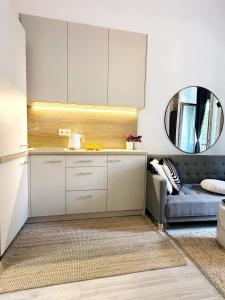 een keuken met witte kasten en een blauwe bank bij Hola Apartamenty Rewolucji 1905r in Łódź +44 foto's