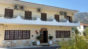 a building with tables and chairs in front of it at romanza rooms in Poulithra