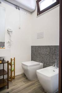 パレルモにあるCasa Vicolo San Giovanniの白いトイレと洗面台のあるバスルーム +8枚の写真