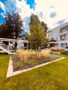 a garden with blue flowers in front of a building at Penthouse Traum - Blick über Arnstadt in Arnstadt