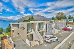 a building with a car parked in a parking lot at Charlies Queenstown Studio Apt 103B in Queenstown