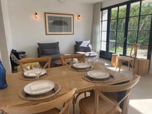 a living room with a wooden table and chairs at Les coquilles la Torche in Penmarcʼh