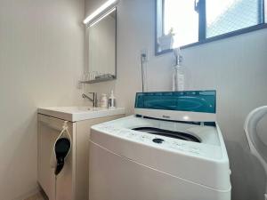 een wasmachine in een badkamer met een wastafel bij Bisuke House in Kyoto +33 foto's