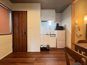 een kleine keuken met een witte koelkast en een tafel bij Bisuke House in Kyoto