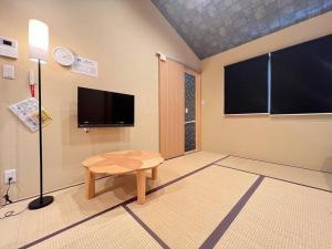 een kamer met een tafel en een flatscreen-tv bij Bisuke House in Kyoto