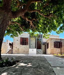 ein Backsteinhaus mit einer Tür unter einem Baum in der Unterkunft Kaizer Suites in Amargeti