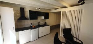 a kitchen with white cabinets and a black counter top at Casa Tabaiba in Parque Holandes