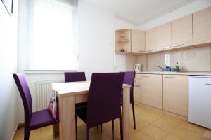 cocina con mesa de madera y sillas moradas en Apartment Hurcak en Zagreb