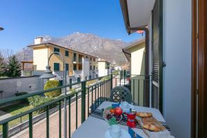 a table with a plate of food on a balcony at Budget Village Apartments - Porto Letizia in Porlezza