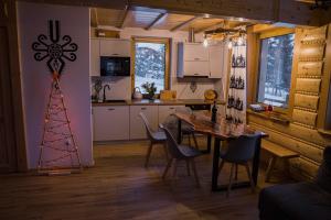 a kitchen and dining room with a table and a christmas tree at Góralskie Domki na Podhalu z jacuzzi in Maniowy