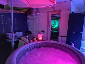 a pink room with a tub filled with pink dye at ÁTICO RILQUE, Apartamentos Independientes con Jacuzzi Privado y Terraza en Ronda in Ronda