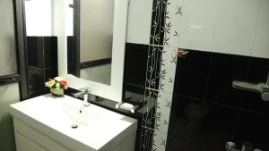 a bathroom with a sink and a mirror and a shower at Holiday Full Time Moratuwa in Moratuwa