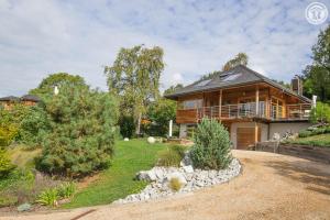 a log house with a porch and a yard at Les perrelles in Bellecombe-en-Beauges