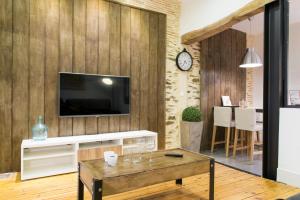 a living room with a tv on a wooden wall at Unsejouranantes - Gîte Lamoricière in Nantes