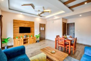 ein Wohnzimmer mit einem blauen Sofa und einem Tisch in der Unterkunft Luxury 2BHK Apartment Near Candolim in Nerul