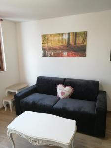 a black couch in a living room with a table at La Casa del Borgo-intero appartamento in Latina