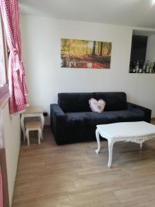a living room with a black couch and a white coffee table at La Casa del Borgo-intero appartamento in Latina