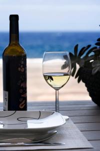 a glass of wine sitting on a table with a bottle of wine at Casa Ana y el Mar - Para Enamorados del Mar - en Lanzarote in Teguise