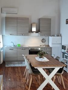 a kitchen with a wooden table and some chairs at Noventa Venice Apartment in Noventa di Piave