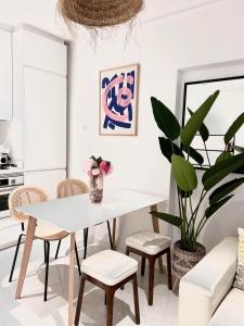 a dining room with a white table and chairs and a potted plant at The Terrace Canalejas in Alicante