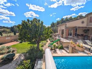 a backyard with a swimming pool and a house at Le Panorama des Alpilles in Aureille
