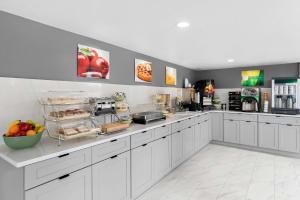 a kitchen with white cabinets and fruits on a counter at Quality Inn Commerce at I-85 in Commerce