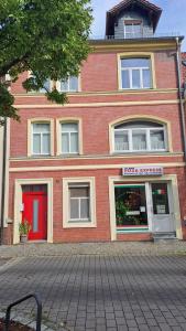 a large brick building with a red door at Schlosswohnung in Calau