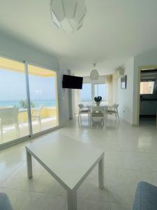 a living room with a table and a view of the ocean at Genial 1ª linea de mar Mediterráneo in Torrox