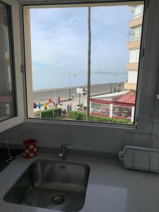 a kitchen sink with a view of a beach from a window at Genial 1ª linea de mar Mediterráneo in Torrox
