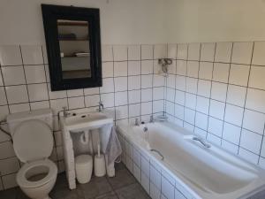a bathroom with a tub and a toilet and a sink at Landsrivier Cottage No 1 in Uniondale