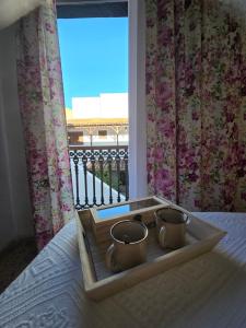 a tray with two tea cups on a bed with a window at Pensión Los Volcanes in Fuencaliente de la Palma +46 photos