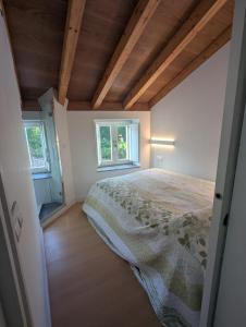 ein Schlafzimmer mit einem Bett und zwei Fenstern in der Unterkunft Casa Muralla in Ribadeo