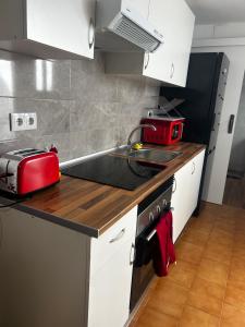 a kitchen with a sink and a red appliance at Mouse House in Novelda