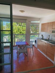 a kitchen with a table and chairs in a room at Plage St-Anne T2 balcon in Sainte-Anne +15 photos