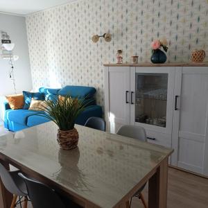 Una sala de estar con una mesa y un sofá azul. en Appartement T2, en Argelès-Gazost