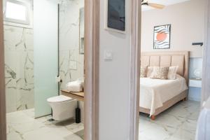 a bedroom with a bed and a shower at Nalu Luxury Suites Adults Only in Kefalos +148 photos