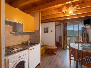 a kitchen with a stove top oven next to a table at Appartement face au lac 6 voyageurs in Les Angles +17 photos