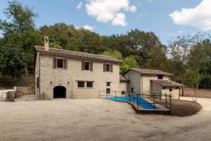 an old stone building with a basketball court in front of it at Mulino in sabina, casale con spa e piscina in Monteleone Sabino