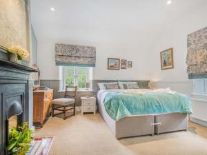 Un dormitorio con una cama, un escritorio y una chimenea. en 4 Bed in Duddon Valley SZ183, en Ulpha