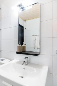 a white bathroom with a sink and a mirror at Northern Lights City Cabin in Rovaniemi