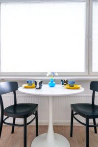 a table with two chairs and a table with dishes on it at Northern Lights City Cabin in Rovaniemi +10 photos