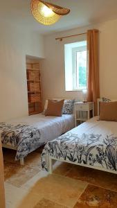 Montignac-de-LauzunにあるLes Gites Sur La Colline - 28 m2 one bedroom gite with shared poolのベッド2台と窓のある寝室